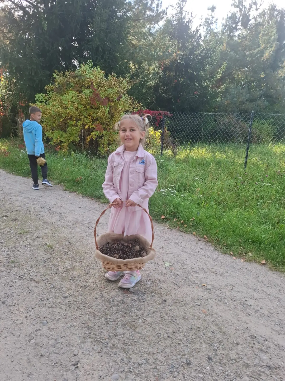 Dzieci ze świetlicy „LIPA” zbierają jesienne liście i szyszki, a następnie wspólnie tworzą z nich słonecznik. Zdjęcia przedstawiają zbieranie materiałów, układanie liści i szyszek oraz gotową pracę z łodygą z patyka i dekoracją z mniejszych kwiatów.