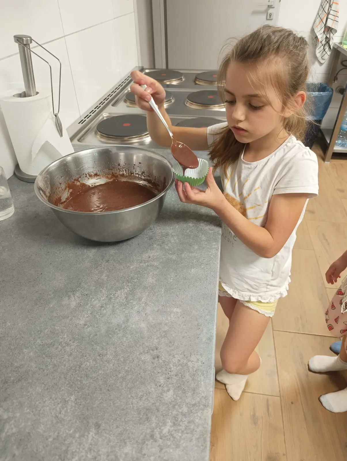 Dzieci przygotowują słodkie babeczki z okazji Dnia Taty podczas zajęć w świetlicy.