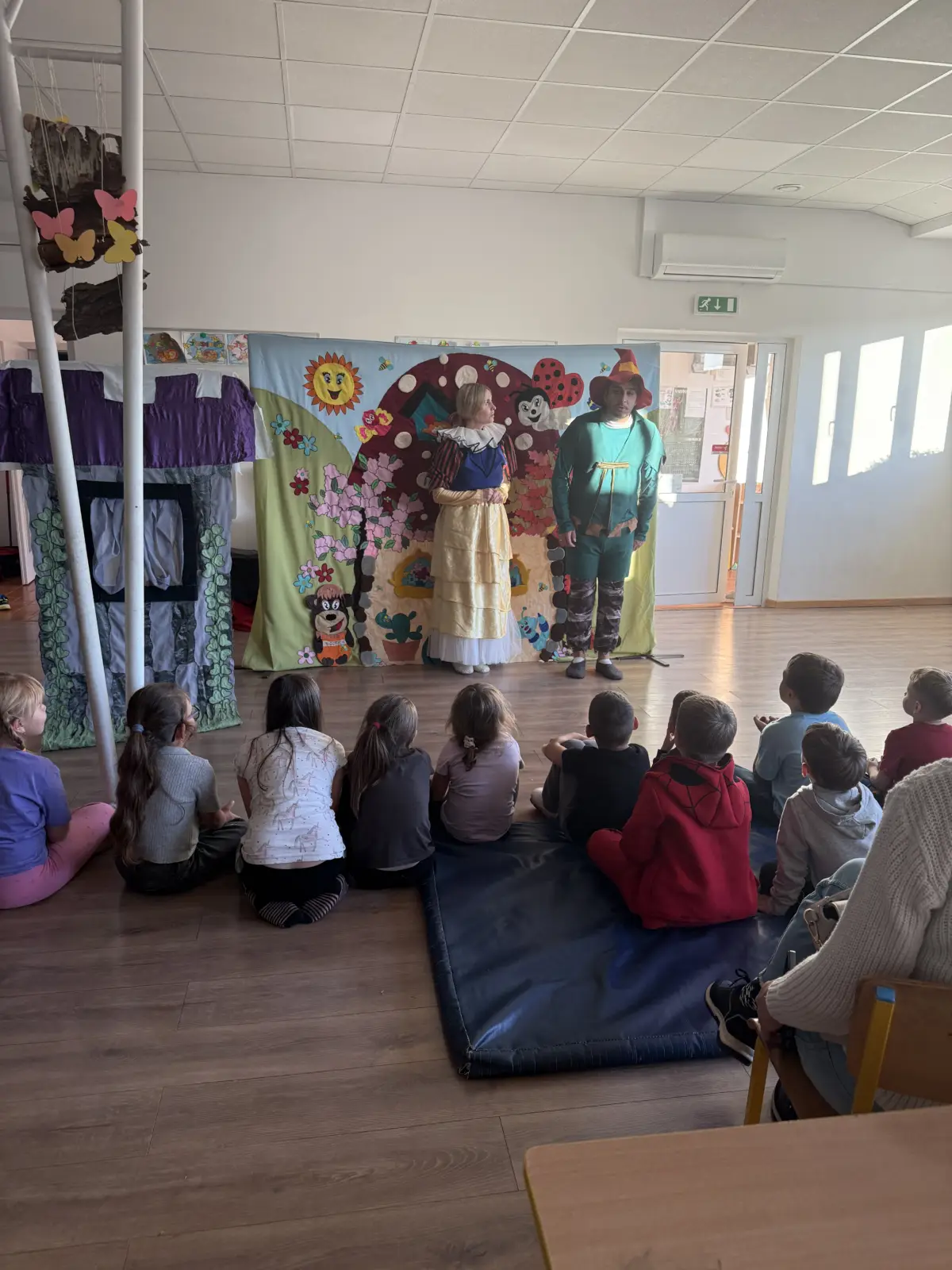 Dzieci oglądają przedstawienie „Królewna Śnieżka i siedmiu krasnoludków” w świetlicy „LIPA” w Łazach, uczestniczą w zabawie z aktorami i pozują do wspólnego zdjęcia.
