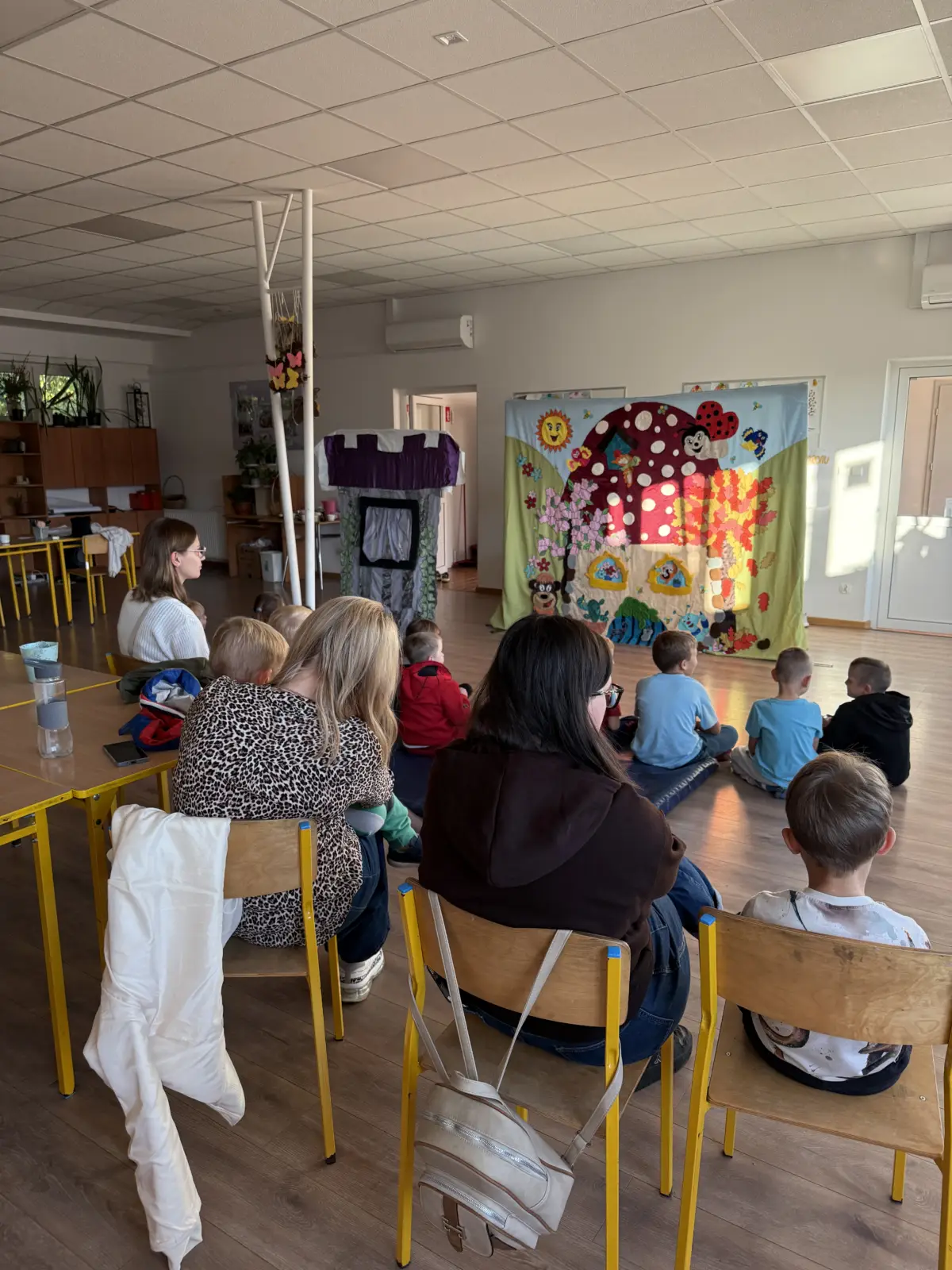 Dzieci oglądają przedstawienie „Królewna Śnieżka i siedmiu krasnoludków” w świetlicy „LIPA” w Łazach, uczestniczą w zabawie z aktorami i pozują do wspólnego zdjęcia.